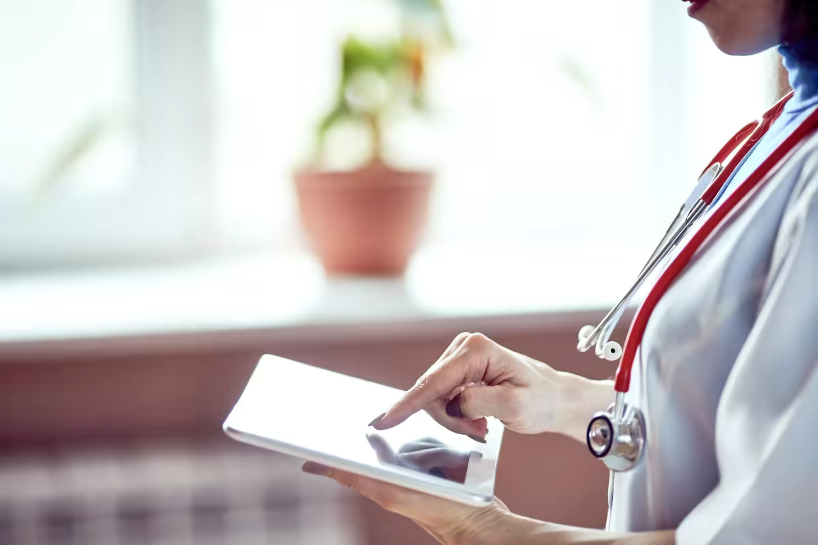 Healthcare compliance officer reviewing vendor credentialing documents at a desk