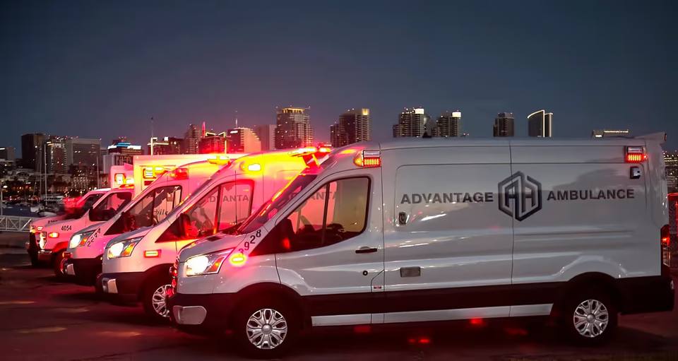 Advantage Ambulance vehicle with paramedics loading equipment outside a hospital