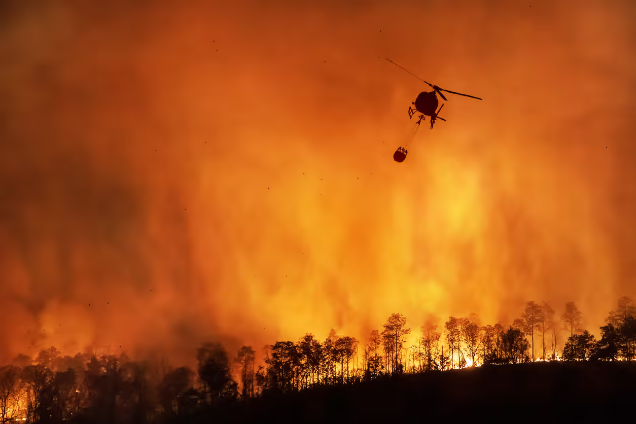Aerial view of wildfire smoke approaching a hospital facility in a California landscape